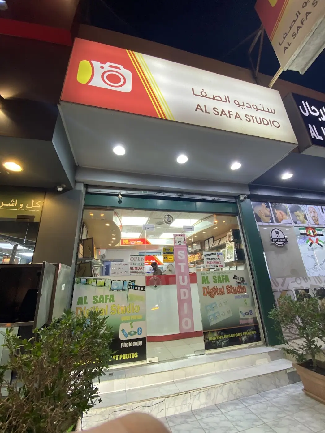 Al Safa Studio storefront on Street 21D at dusk, red and white sign lit